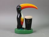 statue of a toucan and a pint of guinness on a table