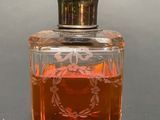 a small glass bottle with an orange liquid inside of it
