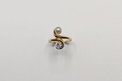 une bague en or sertie d'une perle et d'un diamant
