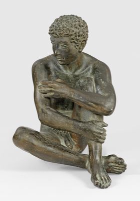 statue en bronze représentant un homme assis par terre, les mains posées sur les genoux