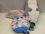 plusieurs peluches posées sur un lit avec un oreiller