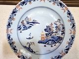 une assiette bleue et blanche sur laquelle est représenté un château