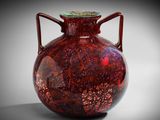 un vase rouge avec un couvercle vert posé sur une table