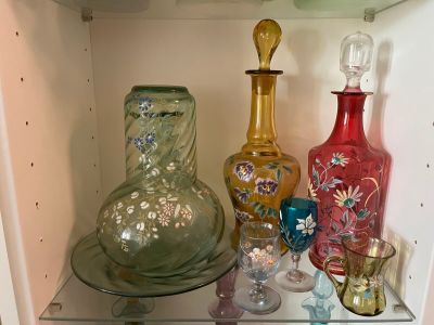 many glass vases on a shelf in a cabinet