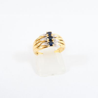 a close up of a gold ring with sapphires and diamonds