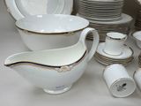 a lot of white and gold china dishes and cups