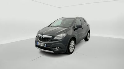 Une voiture grise est garée dans une pièce blanche au sol blanc.