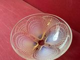 un bol en verre posé sur un canapé rouge, à même le sol