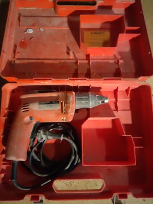 an orange tool box with a drill in it sitting on a table