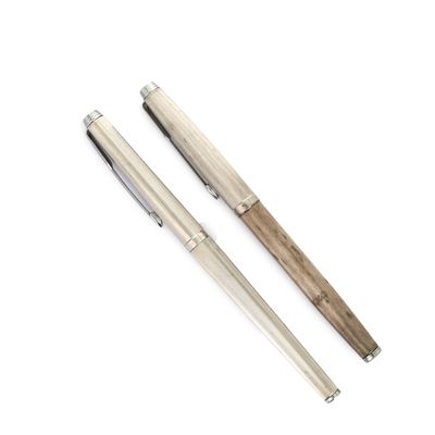 deux stylos assis l'un à côté de l'autre sur une surface blanche