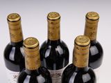 four bottles of wine are lined up in a row on a table