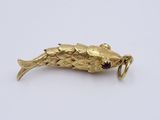 an image of a gold plated fish broochle on a white surface