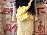 a mannequin wearing a yellow dress with black feathers on it