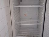 an empty refrigerator in the corner of a room