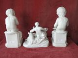three figurines of a man and a woman sitting on boxes