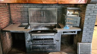 a grill in the middle of a kitchen with a brick wall
