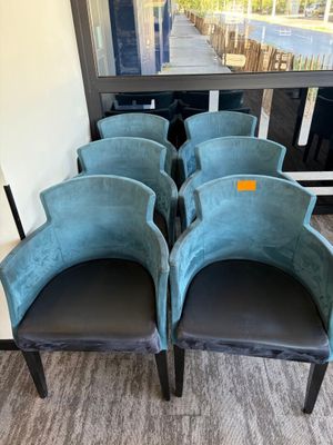 quatre chaises en velours bleu alignées devant une fenêtre