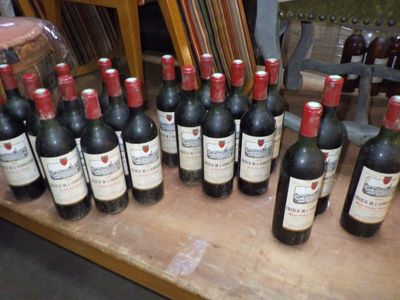 many bottles of wine sitting on a wooden table