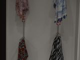 three umbrellas hanging on a hook on the wall