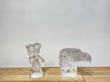 two figurines of animals sitting on a wooden table