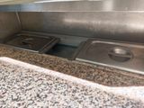 two stainless steel pans sitting on top of a granite counter