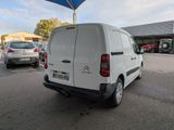 a white van parked in a parking lot with a blue umbrella