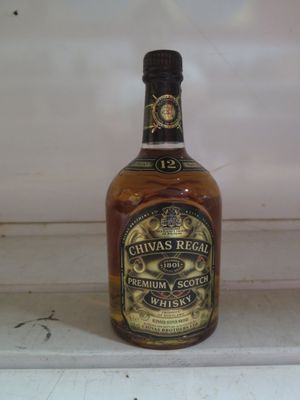 une bouteille de whisky posée sur une étagère devant une fenêtre