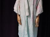 a mannequin dressed in a white robe on a stand