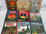 several children ' s books are lined up on a white surface