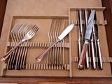 a wooden box with silverware in it on a table