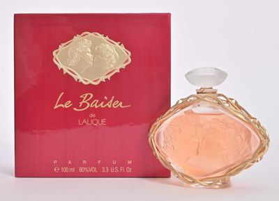un gros plan sur un flacon de parfum à côté d'une boîte rouge