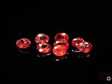 a group of red diamonds sitting on top of a black surface