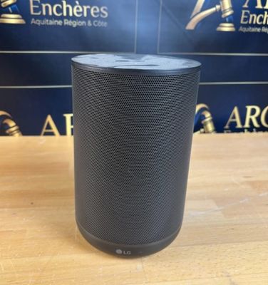une enceinte noire posée sur une table en bois
