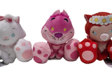three stuffed animals sitting next to each other on a white surface
