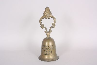 brass bell with ornate design on a white background