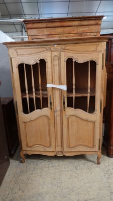 un meuble en bois avec des portes en verre dans une pièce