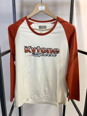 La chemise blanche et orange est suspendue à un portant dans une pièce.