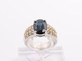a close up of a ring with a blue sapphire and yellow diamonds