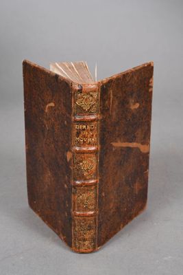 un vieux livre est ouvert sur une table, sur fond gris