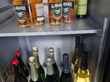 many bottles of alcohol on the shelves in the refrigerator