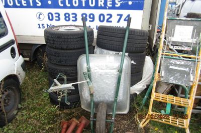 un tas de pneus et une brouette devant un camion
