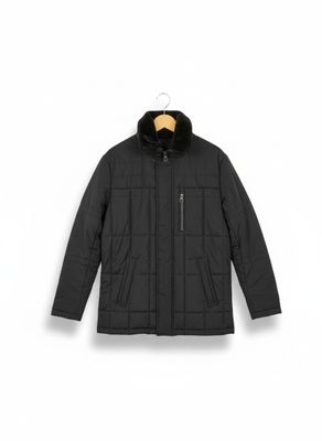 une veste noire à col en fourrure, suspendue à un cintre