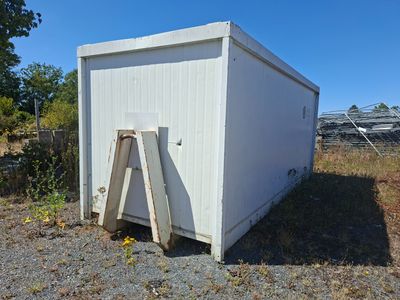 un petit bâtiment blanc contre lequel est appuyée une échelle