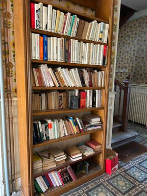 une bibliothèque remplie de livres dans un coin de la pièce