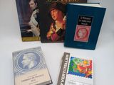 three books are sitting on a white table with a yellow ribbon