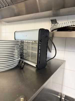 un plan de travail en acier inoxydable sur lequel sont empilés des plats, dans une cuisine professionnelle