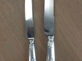 two knives on the table next to each other