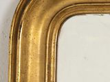 a gold framed mirror on a white wall next to a white wall