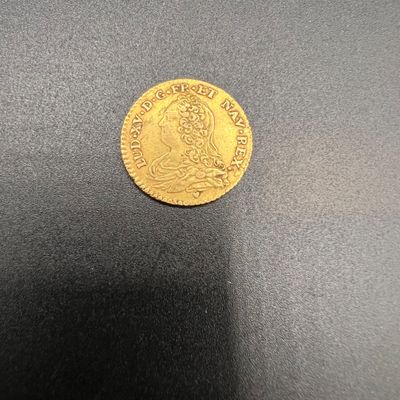 une pièce d'or sur une surface noire