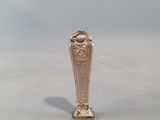 a small silver vase sitting on top of a white table